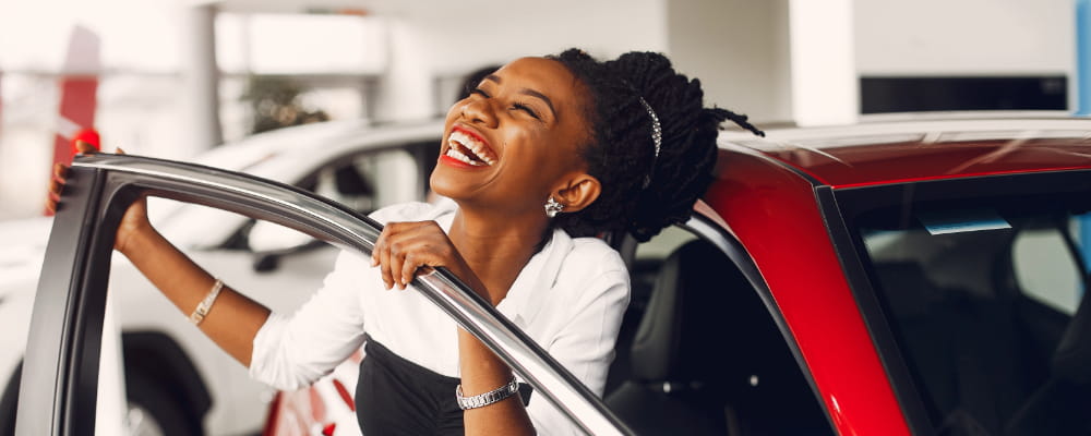 Stylish black woman in a car salon.